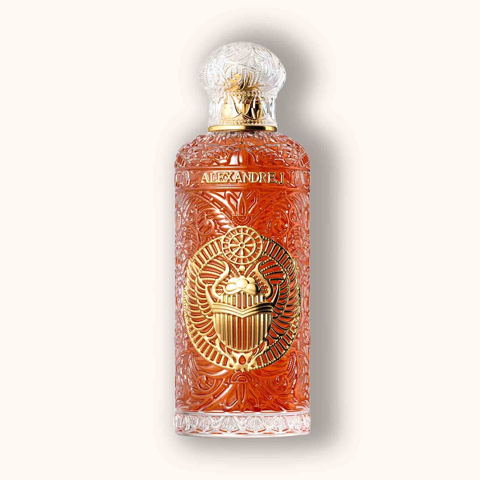 Alt text: A beautifully designed bottle of Alexandre.J Gold Black Beetle fragrance, featuring intricate gold and clear glass detailing with an ornate beetle emblem on the front, set against a soft beige background.