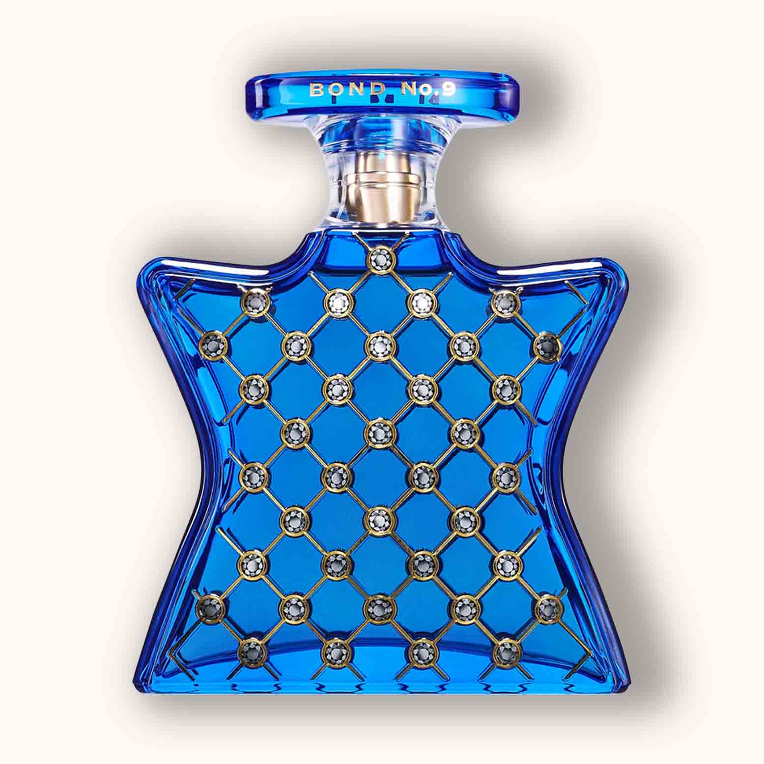 Alt text: A striking blue glass perfume bottle shaped like a star, adorned with a patterned design featuring sparkling embellishments, labeled 'Bond No.9 NoMad'.