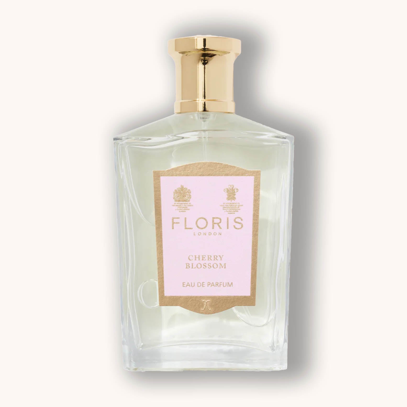 Alt text: A sleek glass bottle of Floris London Cherry Blossom Eau de Parfum, featuring a pale pink label with gold accents and a classic gold cap. The fragrance embodies the delicate scent of cherry blossoms.