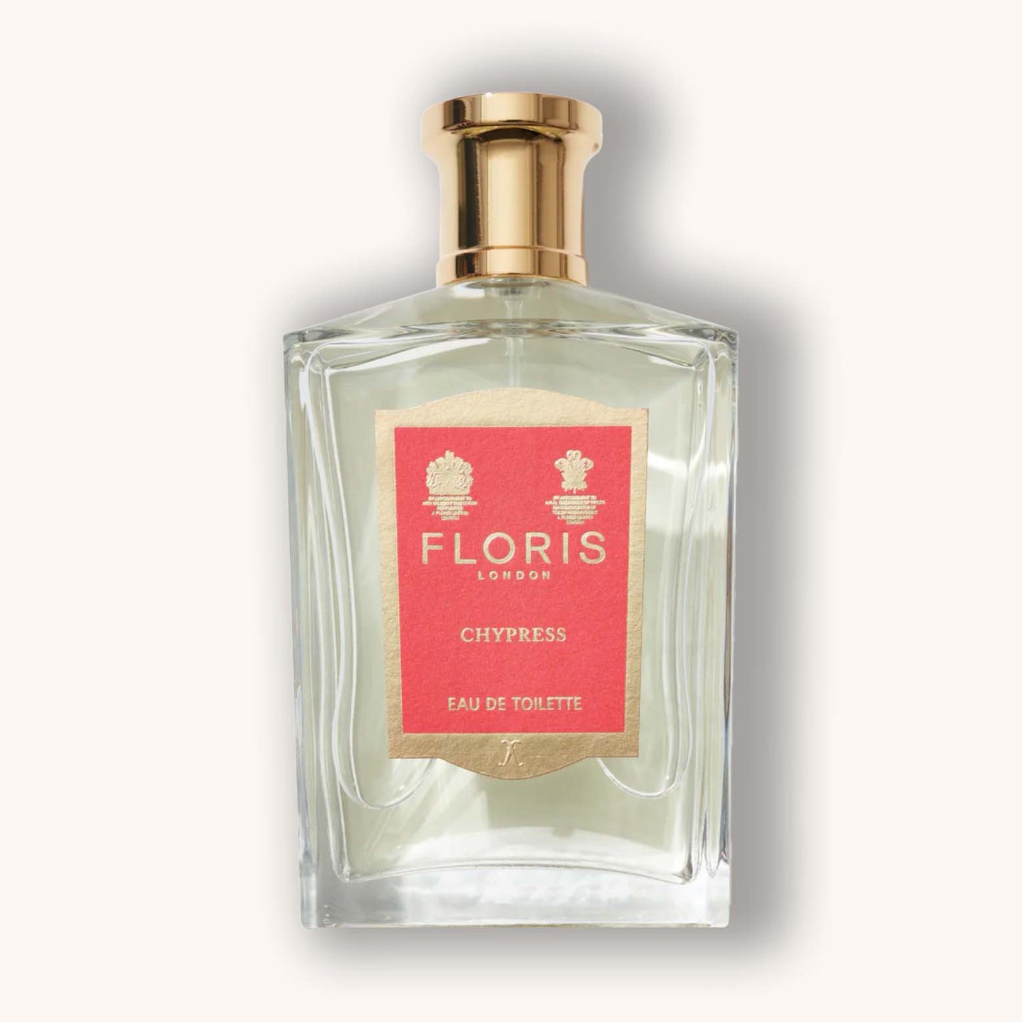 Alt text: A clear glass bottle of Floris London Chypress Eau de Toilette, featuring a gold cap and a distinct coral label with elegant floral accents.