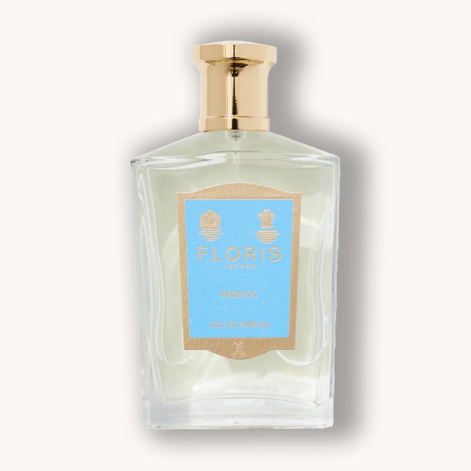 Alt text: A clear glass bottle of Floris London Sirena perfume, featuring a soft blue label and gold accents, exuding elegance and sophistication.