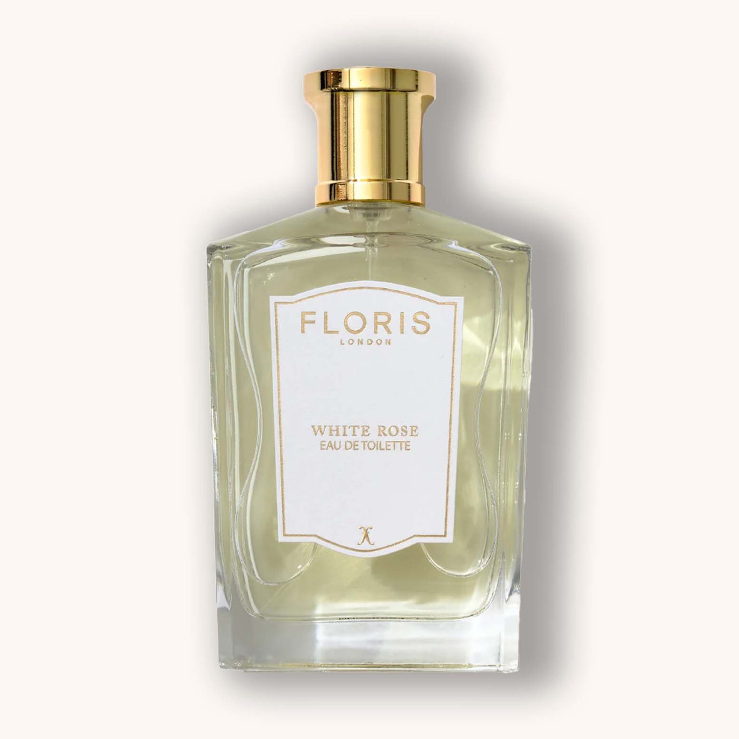 Alt text: A clear glass bottle of Floris London White Rose Eau de Toilette, featuring a gold cap and elegant label design, showcasing a light, floral fragrance.