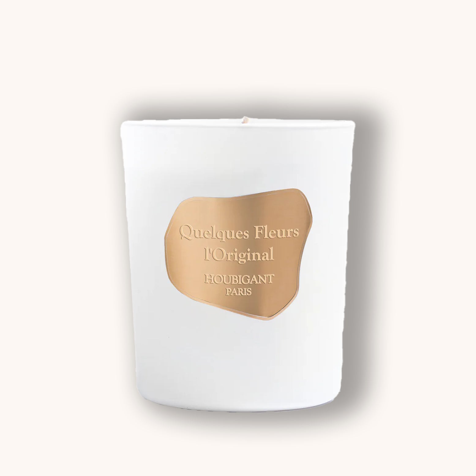 White candle with a gold label on a white background