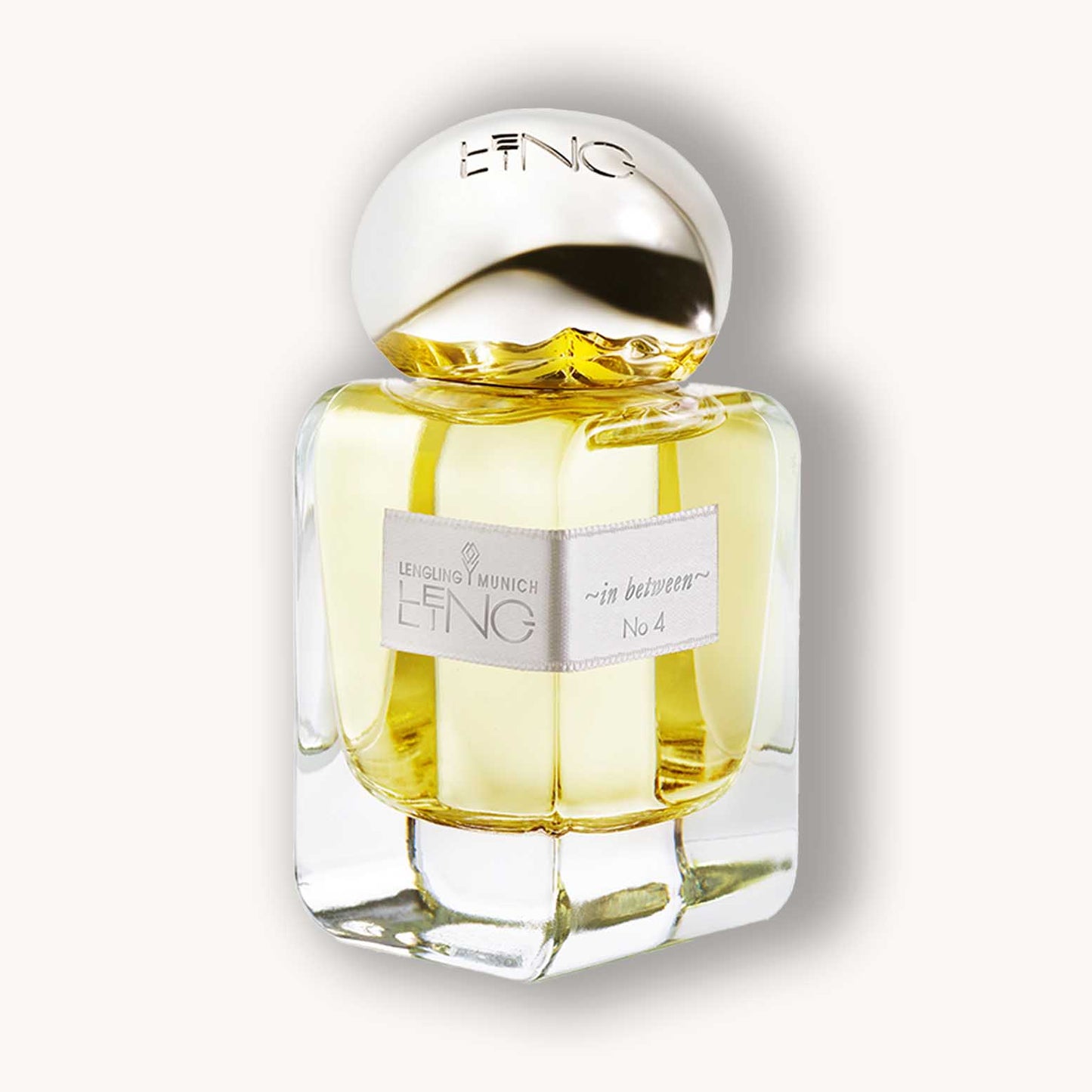 Alt text: A stylish glass perfume bottle labeled "Lengling No 4 - In Between," featuring a sleek design with a gold cap and a soft yellow fragrance.