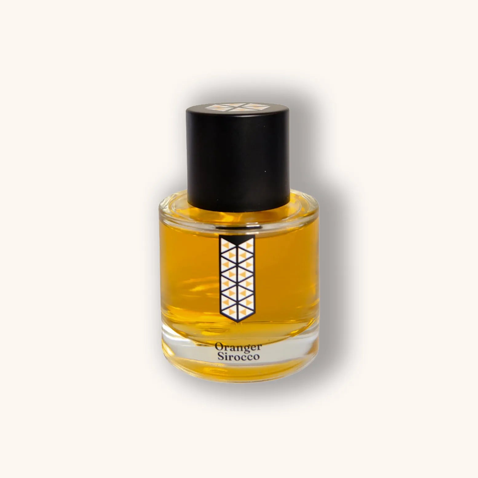 Alt text: A glass bottle of Les Indémodables Oranger Sirocco perfume, featuring a geometric label and a black cap, filled with a golden-orange fragrance.