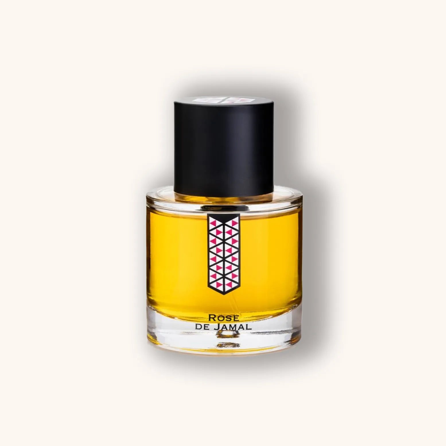 Alt text: A glass perfume bottle of "Les Indémodables Rose de Jamal" featuring a hexagonal design on the label, filled with a vibrant golden liquid and topped with a sleek black cap.