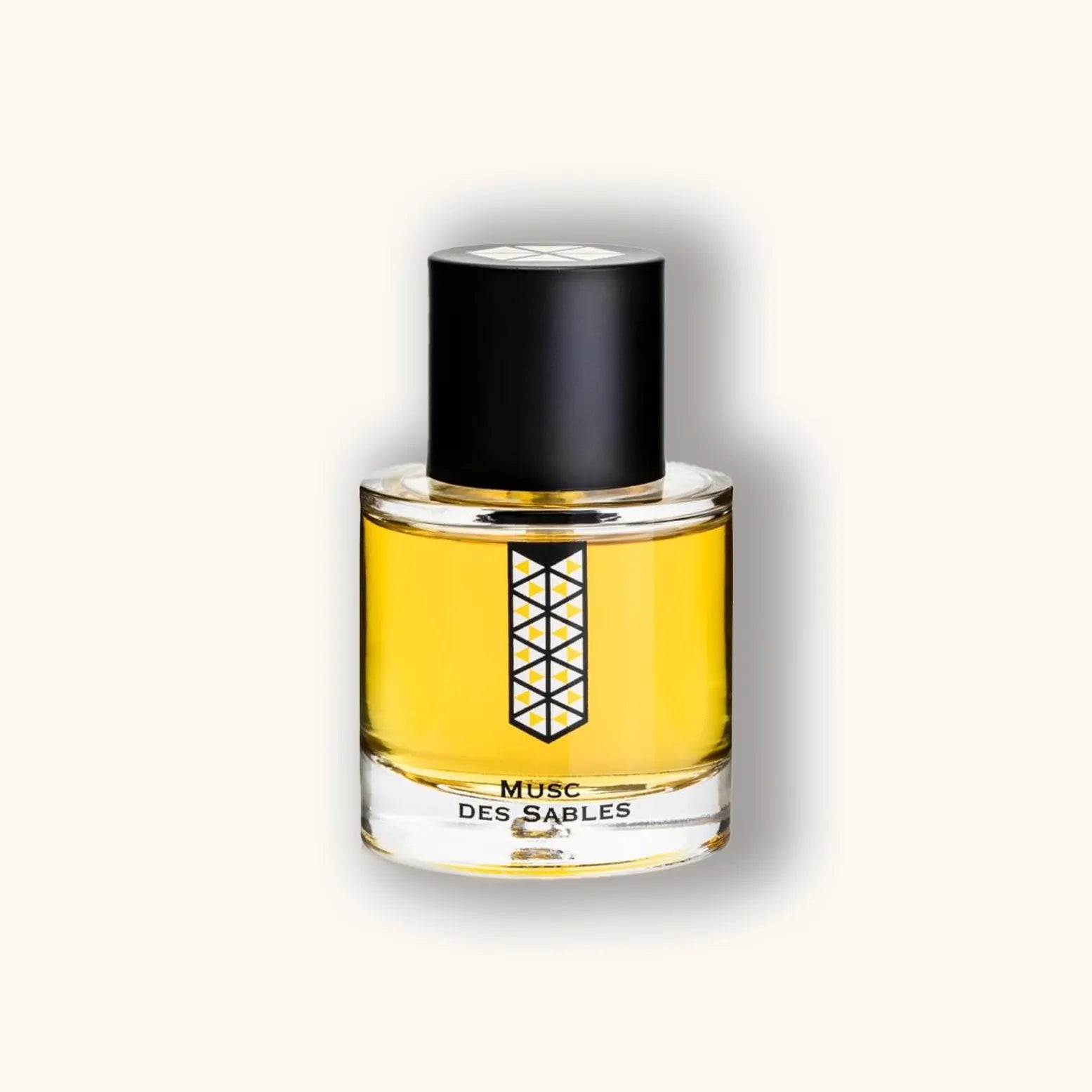 Alt text: A sleek glass bottle of 'Les Indémodables Musc Des Sables' perfume, featuring a black cap and a minimalist design. The liquid inside is a warm, golden yellow, suggesting an alluring fragrance.