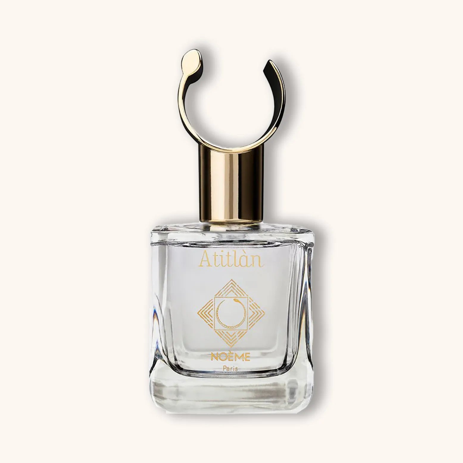 Alt text: A sleek glass perfume bottle of Noème Paris Atitlan, featuring a gold cap and the brand's logo elegantly displayed on the front. The design is minimalist and sophisticated.