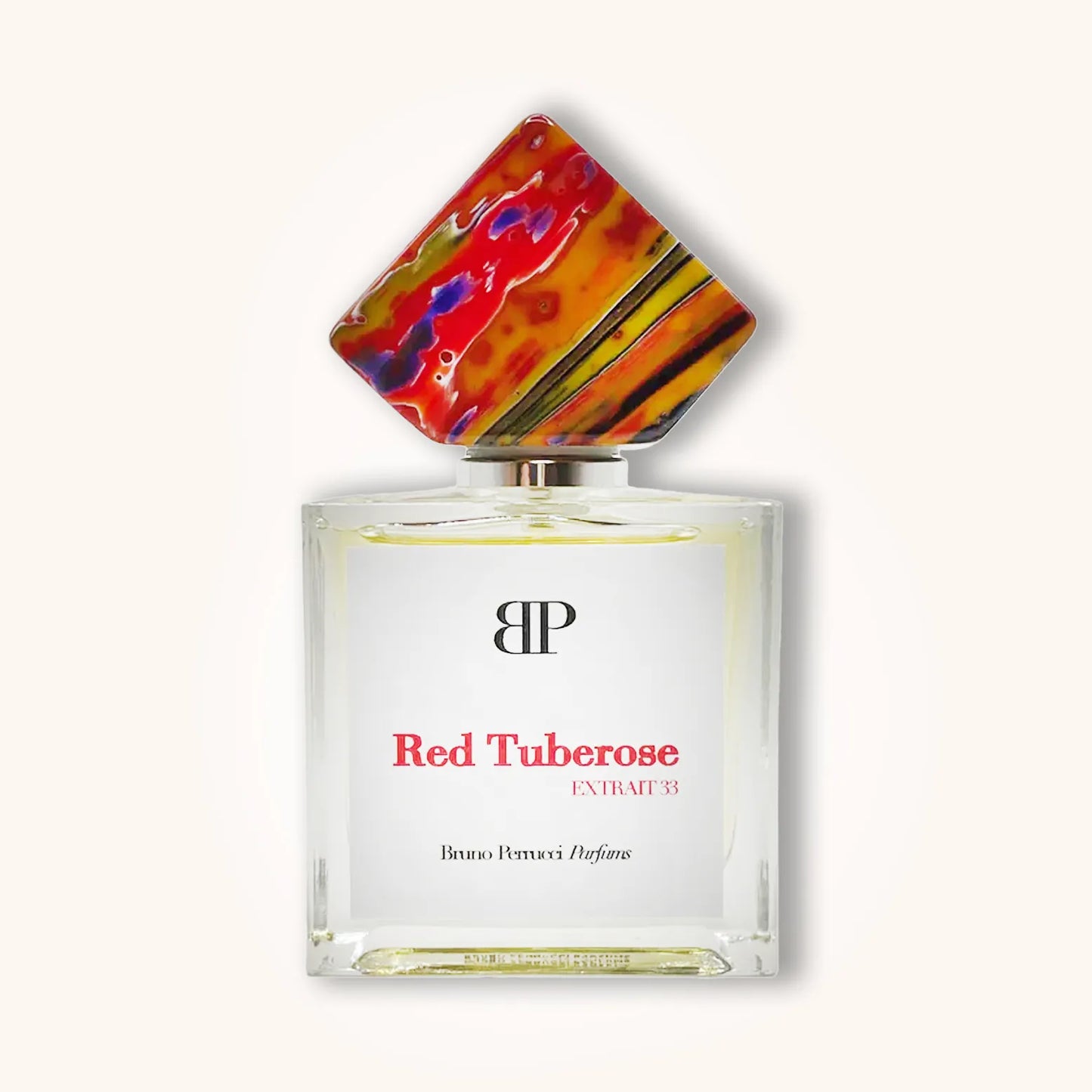 A bottle of Bruno Perrucci Red Tuberose perfume, featuring a striking, multicolored cap and an elegant, minimalist design. The label prominently displays "Red Tuberose EXTRAT 33."