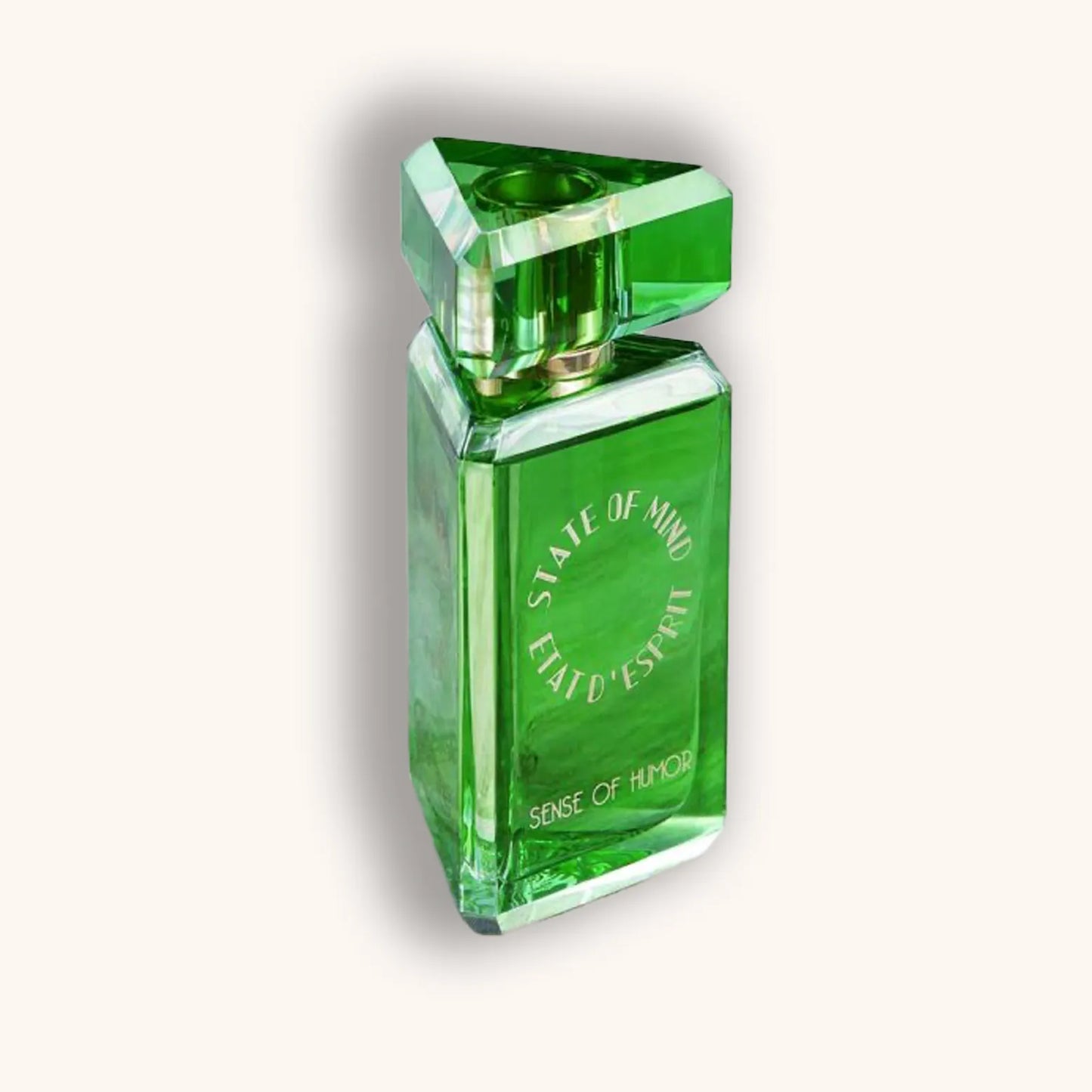 A green glass perfume bottle featuring the label "State of Mind Sense of Humor," designed with a unique triangular cap and an elegant, modern shape.