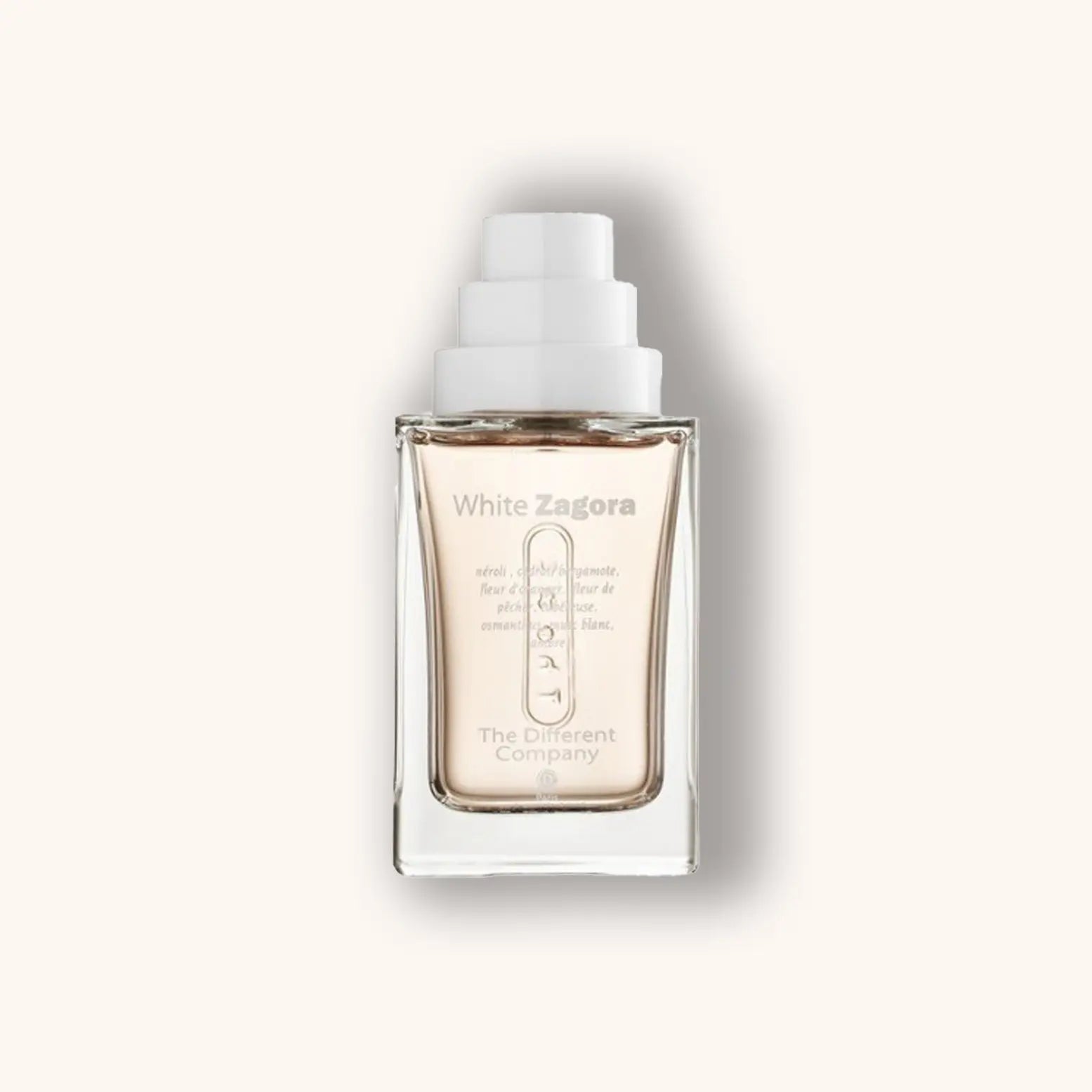 Alt text: A sleek glass bottle of "The Different Company White Zagora" fragrance, featuring a minimalist design with a white cap and label, set against a soft beige background.