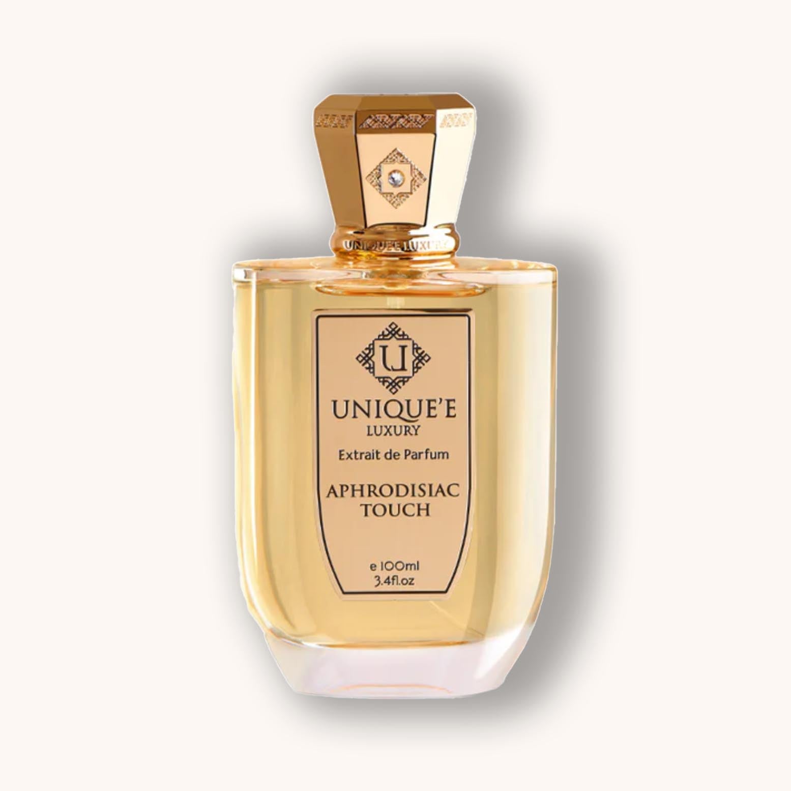A bottle of Unique'e Luxury Aphrodisiac Touch perfume, featuring an elegant design with a golden hue and ornate cap. The fragrance is showcased in a 100ml glass bottle, highlighting its luxurious appeal.