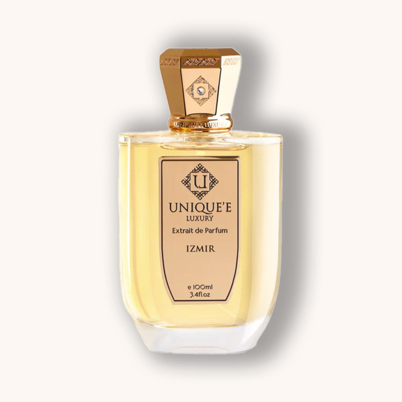 Alt text: A stylish bottle of Unique'e Luxury Izmir perfume, featuring a golden cap and elegant label. The clear liquid inside showcases the fragrance's premium quality, housed in a modern design.