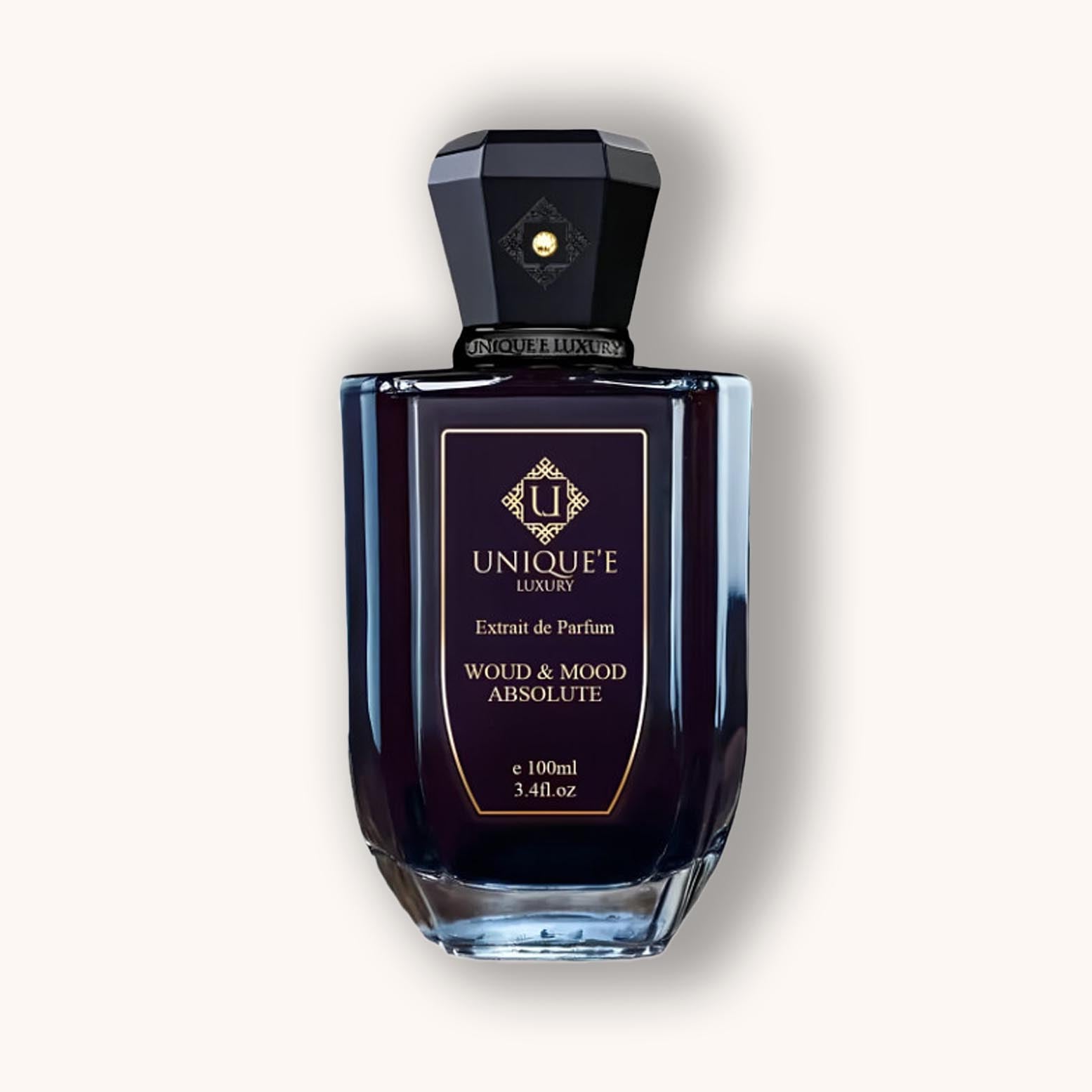 Alt text: A dark, elegantly designed perfume bottle of 'Unique'e Luxury Woud and Mood Absolute', featuring a chic hexagonal cap and gold accents, containing 100ml of exquisite fragrance.