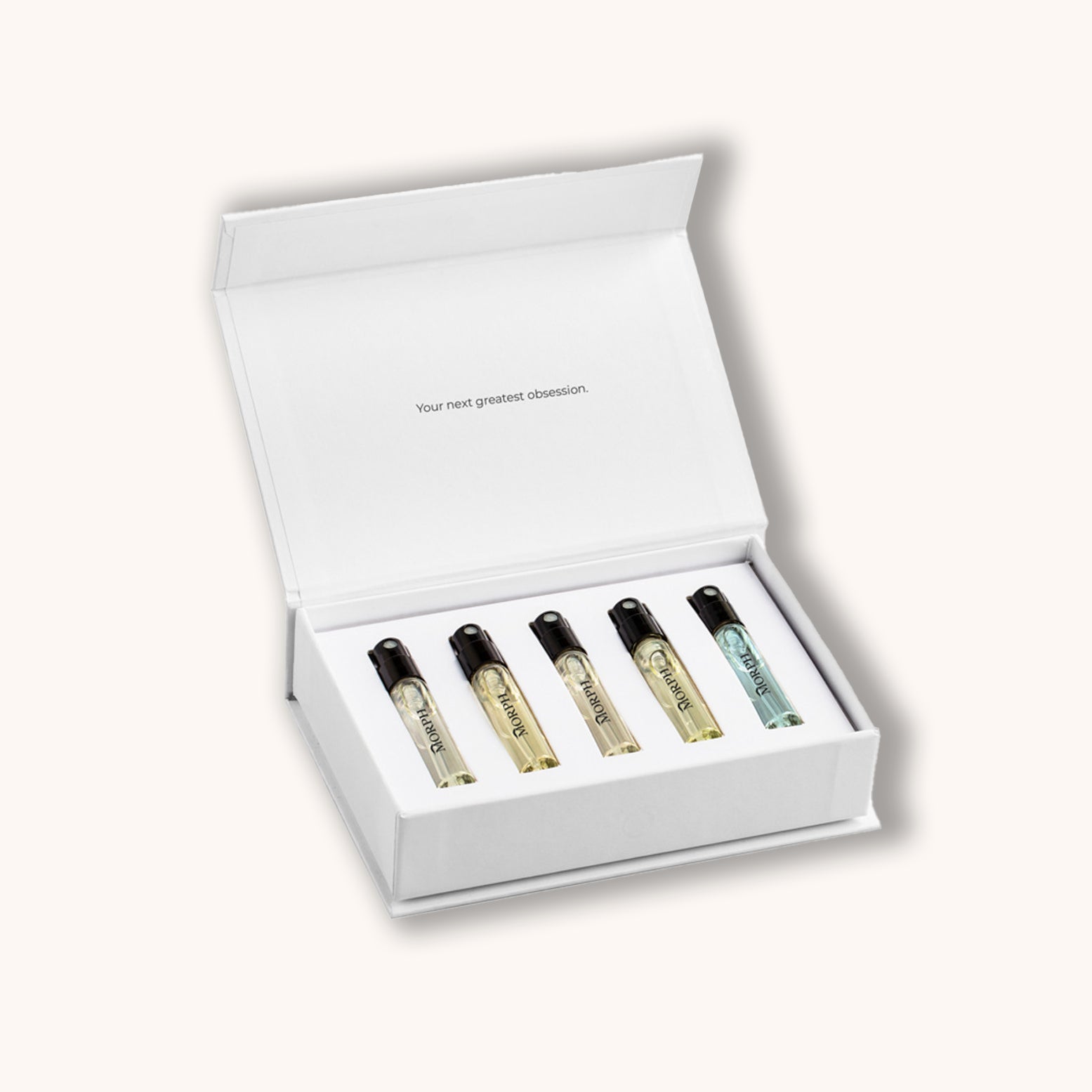 Set of five small perfume bottles in a white box on a light gray background