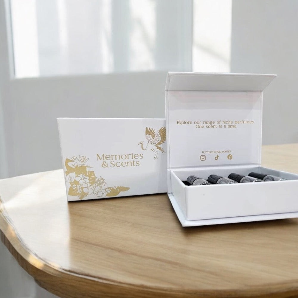 Alt tag: A neatly arranged Discovery Box Spring from Memories & Scents, featuring a selection of niche perfumes in small vials, presented in an elegant white box with gold detailing.
