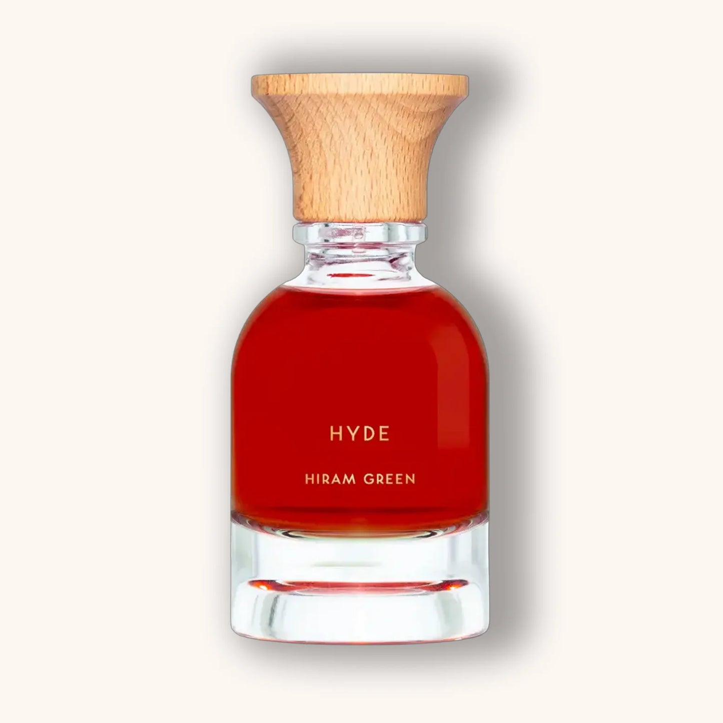 Hiram Green Hyde fragrance in a deep red natural perfume bottle with wooden cap, minimalist style.