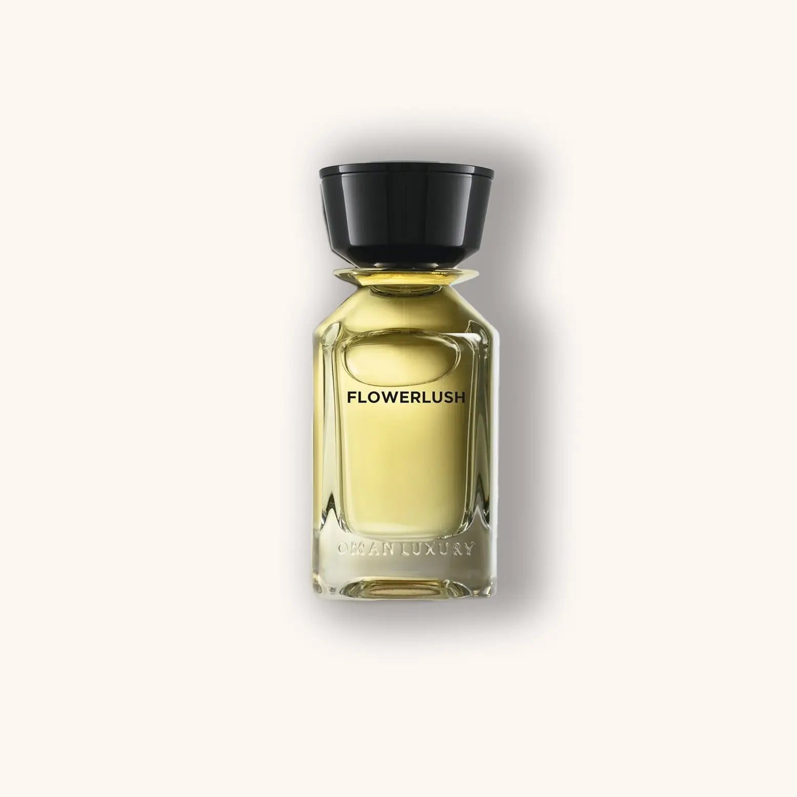 Alt text: A sleek glass bottle of Omanluxury Flowerlush perfume featuring a black cap and an elegant, minimalist design, showcasing its rich golden fragrance inside.
