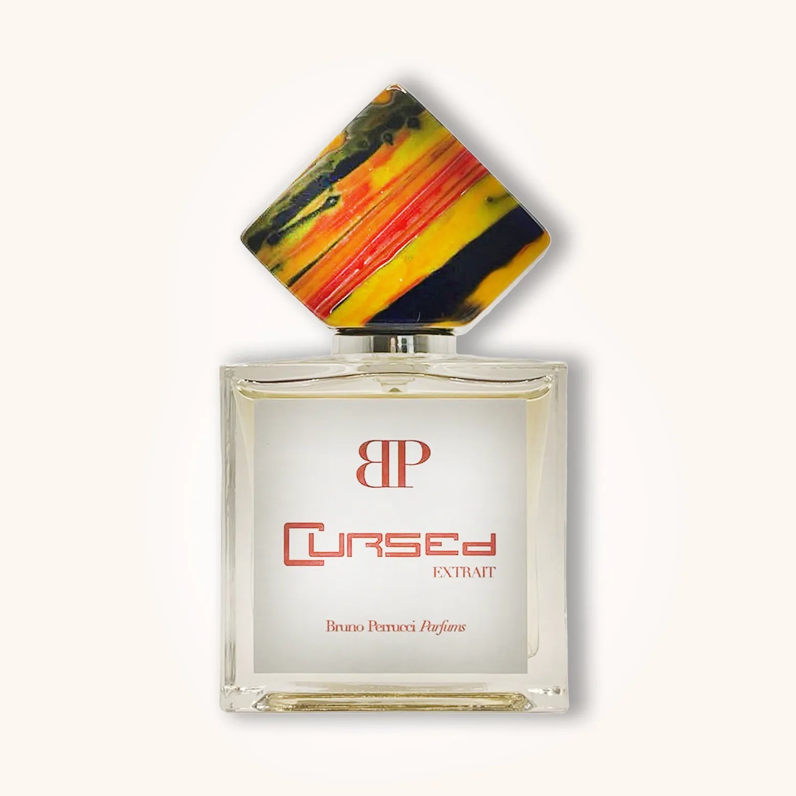Alt text: A bottle of Bruno Perrucci Cursed, featuring a unique geometric cap with vibrant colors and a sleek glass design. The label prominently displays the word "Cursed" along with "EXTRAIT."