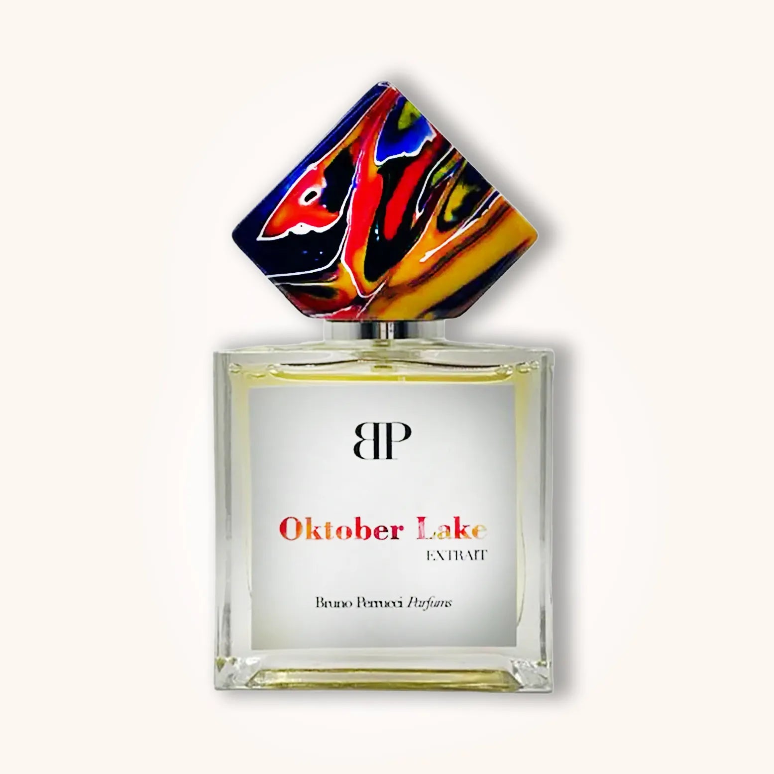 Alt text: A bottle of Bruno Perrucci Oktober Lake perfume, featuring a sleek glass design and a colorful, artistic cap. The label prominently displays the name "Oktober Lake" and "Extrait."